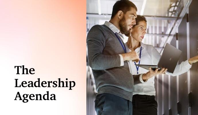Two workers talking in front of a wall of servers with the words “The Leadership Agenda” superimposed on the image