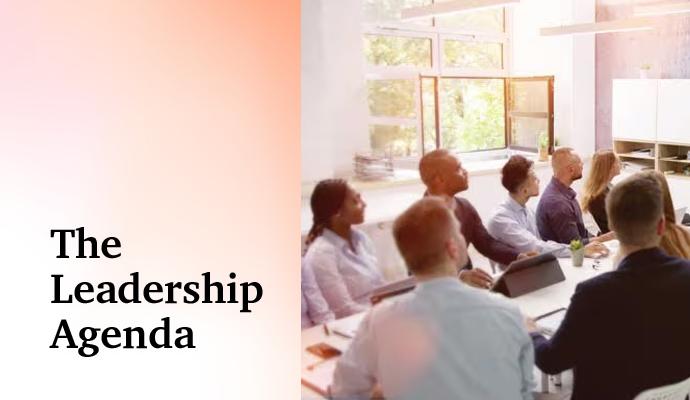 An ethnically diverse group of people at a conference table with the words “The Leadership Agenda” superimposed