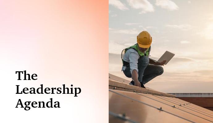 Photograph of a worker inspecting solar panels  with the words "The Leadership Agenda" superimposed