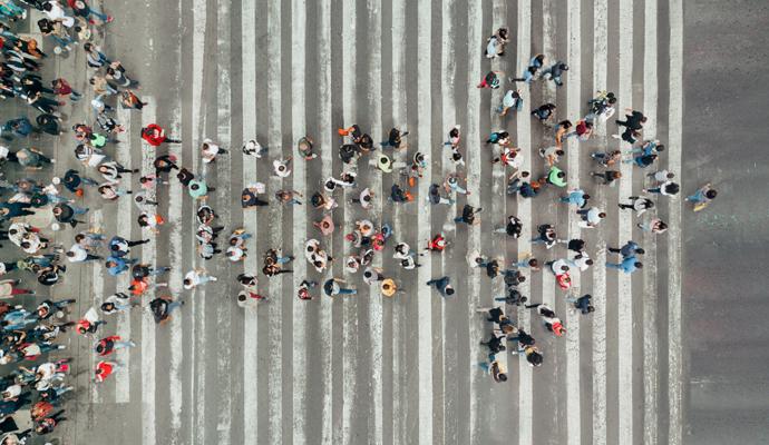 Photograph from above of a group of people gathering to form the shape of an arrow